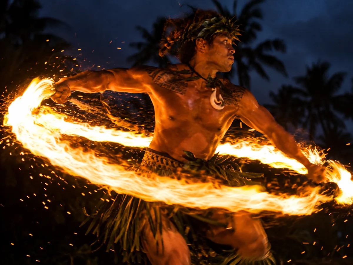 Polynesian fire-knife dancer spinning a ring of flame at night